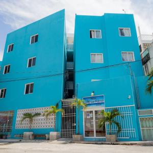 a blue building with palm trees in front of it at Hotel Las Palmas en Laurel in Cancún