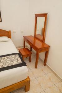 a bedroom with a wooden desk and a mirror at Hotel Las Palmas en Laurel in Cancún
