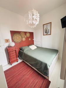 a bedroom with a bed and a chandelier at L'Attrape Coeur in La Baule