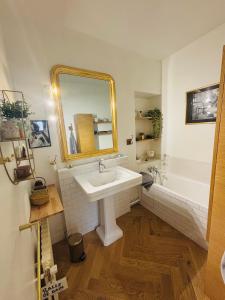a bathroom with a sink and a mirror and a tub at L'Attrape Coeur in La Baule +27 photos