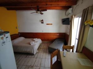 a small room with a bed and a couch at Complejo EL ALTO in Tanti +17 photos