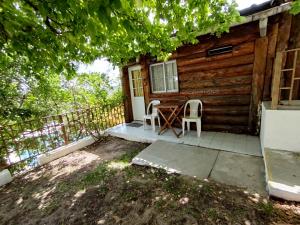 a cabin with a table and two chairs on the porch at Complejo EL ALTO in Tanti