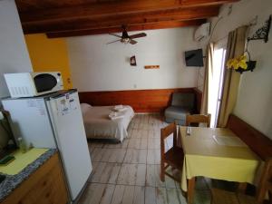 a small kitchen with a refrigerator and a table at Complejo EL ALTO in Tanti