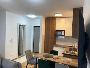 a kitchen with a table and chairs in a room at Apartman MM Vrnjacka Banja in Vrnjci