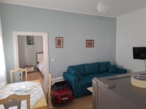 Una sala de estar con un sofá azul y una mesa. en Vila Konti 42, en Durrës