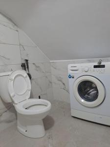 a bathroom with a toilet and a washing machine at Vila Konti 42 in Durrës +20 photos
