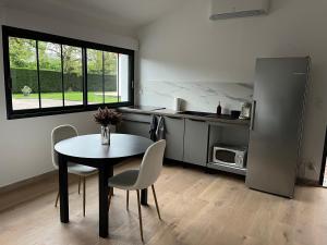 a kitchen with a table and chairs and a table and a window at Studio climatisé confortable et calme in Pampelonne
