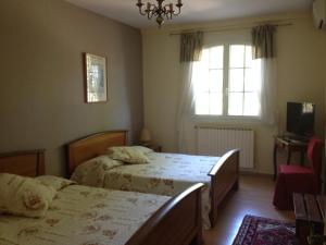 a bedroom with two beds and a window at Logis du Comte in Suze-la-Rousse