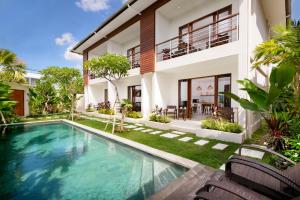 
a large white swimming pool in front of a house at Echo Beach Villa and Apartment in Canggu
