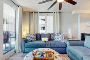 een woonkamer met een blauwe bank en een tafel bij Nautilus 2507 in Fort Walton Beach