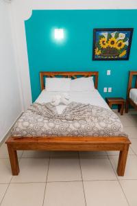 a bedroom with a bed with a blue wall at Hotel Las Palmas en Laurel in Cancún