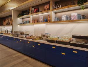 a kitchen with blue cabinets and food on display at Adina Apartment Hotel Cologne in Cologne +37 photos
