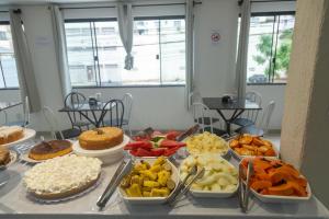 a table topped with trays of different types of food at HANNA Balneário Hotel in Balneário Camboriú