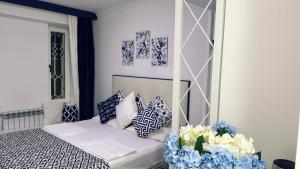 a bedroom with a bed with blue and white pillows at Hotel Tigran Mets Yerevan in Yerevan