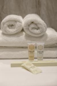 a couple of towels and two products on a table at The First Apart Hotel in Almaty