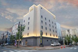 a large white building on the corner of a street at Justsleep hotel Cheonan Dujeong branch in Cheonan