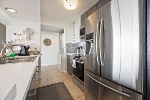 a kitchen with a stainless steel refrigerator and a sink at Lakefront Condo Retreat in Montgomery