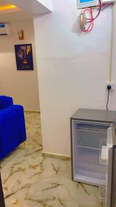 a corner of a room with an empty refrigerator at The Diamond Boho Apartment in Ibadan +5 photos