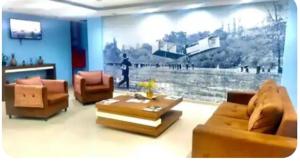 a living room with two couches and a large painting at Via Mar Loft in Macaé +2 photos