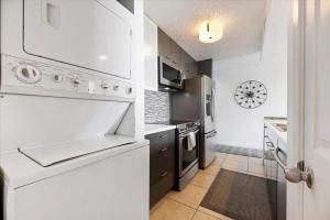 a kitchen with white appliances and a stove top oven at Lakefront Condo Retreat in Montgomery +27 photos