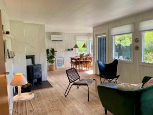 a living room with a couch and chairs and a table at Cozy summer cottage with orangery close to Heatherhill and Beach in Vejby