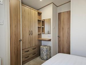 a bedroom with wooden cabinets and a bed at Grange Leisure Park, Mablethorpe in Mablethorpe +38 photos