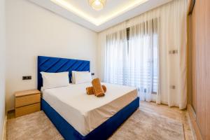 a bedroom with a blue and white bed and a window at Madani Palazza Appart & Duplex in Marrakech