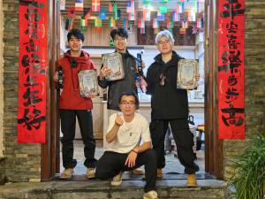 张家界Breeze & Alley Inn--Tianmenshan Cableway-English reception-Tourism planing的一群人拿着证书站在门口