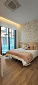 a bedroom with a large bed with a wooden floor at Apartamento Diseño Rosa in Ponteareas
