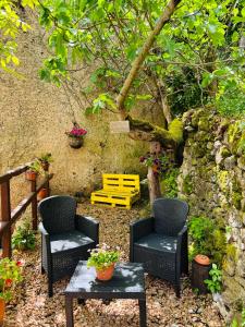 a patio with two chairs and a table and a yellow bench at Osini Ecciu Home in Osini +26 photos