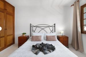 a bedroom with a white bed with a black headboard at Apartamento Sol 'Vistas al Mar y al Teide' in Alcalá