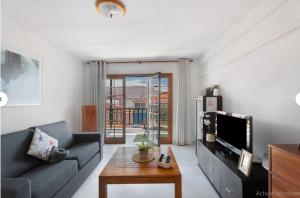 a living room with a couch and a tv at Apartamento Sol 'Vistas al Mar y al Teide' in Alcalá