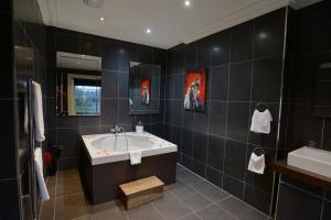 a bathroom with a sink, toilet, and bathtub at Park House Hotel in Shifnal