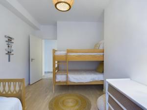 a bedroom with two bunk beds in a room at 50m de la plage - terrasse - 3 adultes et 3 enfants in Pléneuf-Val-André