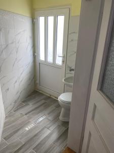 a bathroom with a toilet and a sink and a window at Casa Chri in Făgăraş