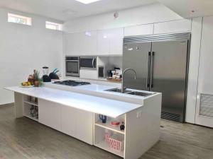 a kitchen with a sink and a refrigerator at Lomas del Encanto, villa en la montaña cerca del mar in La Asunción
