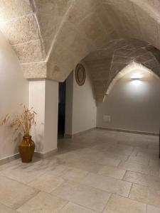 una grande stanza con un orologio sul muro e un vaso di Terra D`Itria a Fasano