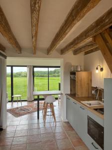 a kitchen with a table and a large window at Cottages du Golf Fleuray-Amboise in Cangey
