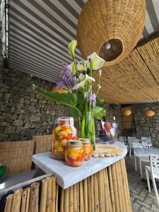 Una mesa con frascos de fruta y flores sobre ella. en Pensione Sorriso, en Vernazza