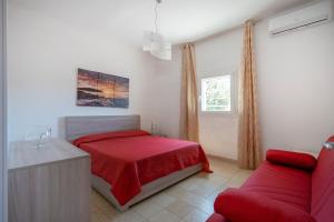 a bedroom with a red bed and a couch at Villa Stellina in Ostuni