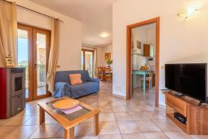 a living room with a couch and a tv at Casa Valeria Costa Paradiso in Li Valcaggi