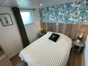 a small bedroom with a bed and a window at Lieu paisible et indépendant in Bégard