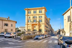 Un edificio amarillo con coches aparcados en un estacionamiento. en Lavinia's Apartment at Colosseo, en Roma
