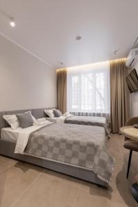 a bedroom with two beds and a large window at The First Apart Hotel in Almaty