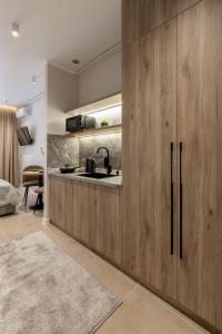 a kitchen with wooden cabinets and a sink at The First Apart Hotel in Almaty +42 photos