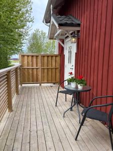 a deck with a table and chairs on a red house at Sveabo in Kumla