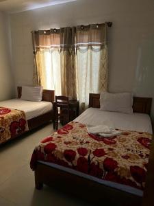Un dormitorio con dos camas y una ventana. en Nhà nghỉ THANH HẰNG, en Hue