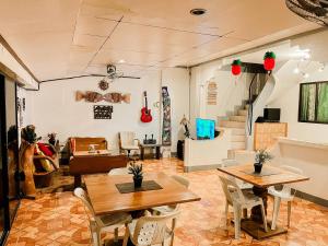 a living room with tables and chairs and a staircase at Mario's Travellers Inn in Coron