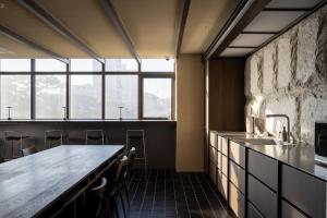a kitchen with a long counter and some windows at Extay Dongdaemun in Seoul