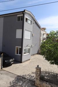 a building with a car parked in front of it at Apartmani MULIC Sutomore in Sutomore
